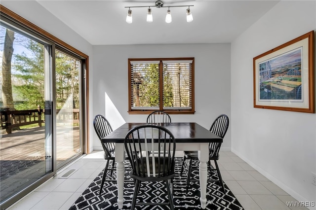 dining space with baseboards, light tile patterned floors, and a wealth of natural light
