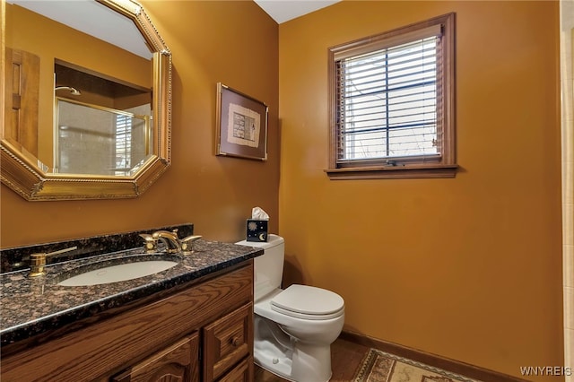 full bathroom featuring toilet, a tile shower, and vanity