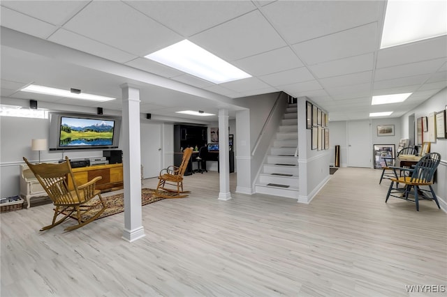 interior space with stairs, baseboards, a paneled ceiling, and light wood-type flooring