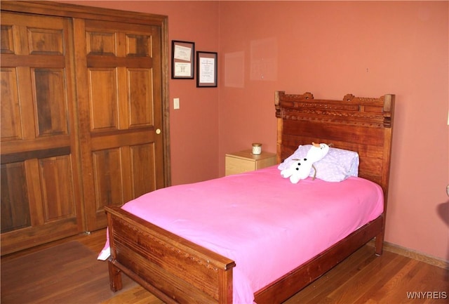 bedroom with baseboards and wood finished floors