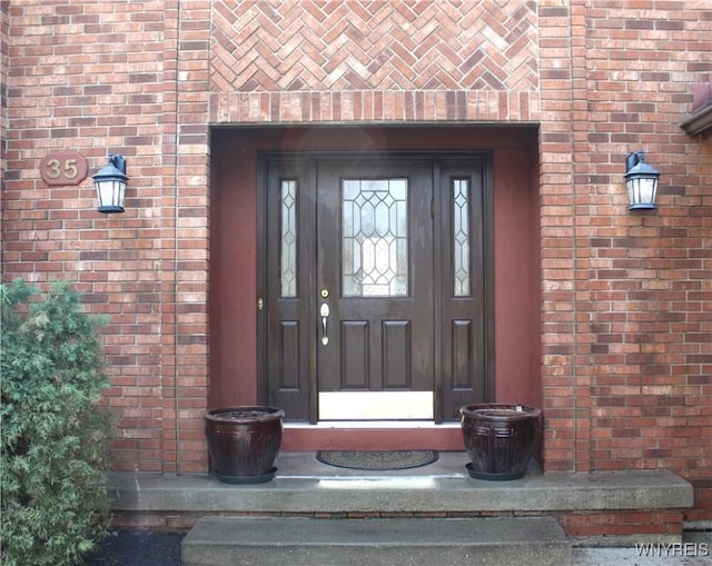 view of exterior entry featuring brick siding