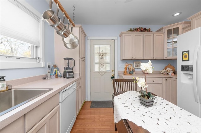 kitchen with white appliances, glass insert cabinets, light wood-style floors, recessed lighting, and light countertops