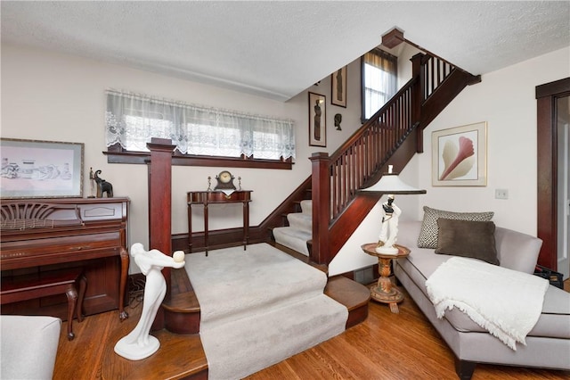 interior space featuring a textured ceiling, stairs, and wood finished floors