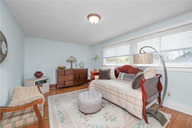 living area with baseboards and wood finished floors
