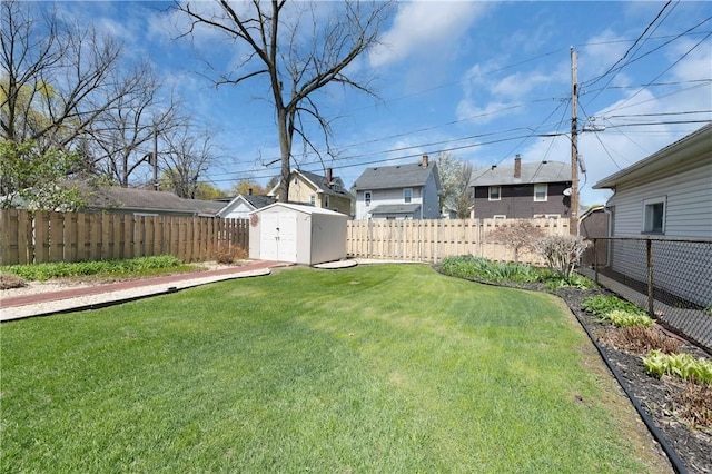 view of yard featuring an outdoor structure, a fenced backyard, a storage shed, and a residential view