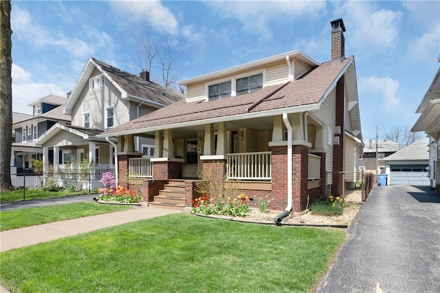 bungalow-style house with a front lawn, fence, covered porch, a chimney, and brick siding