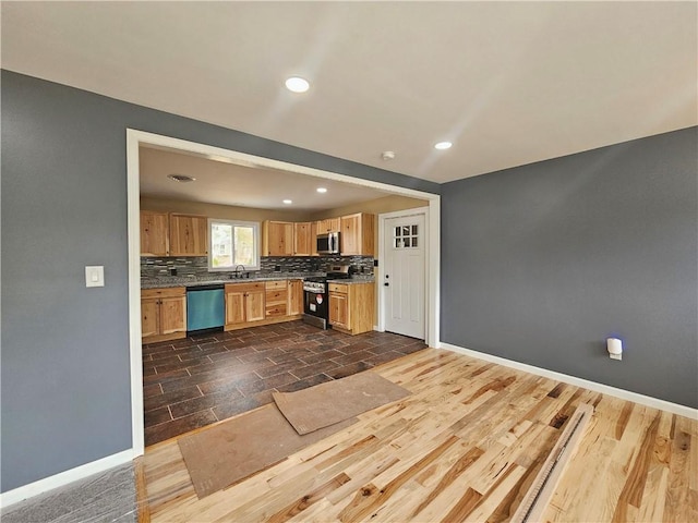 kitchen featuring tasteful backsplash, a sink, baseboards, stainless steel appliances, and recessed lighting