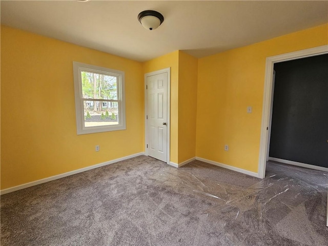 unfurnished room featuring baseboards and carpet flooring