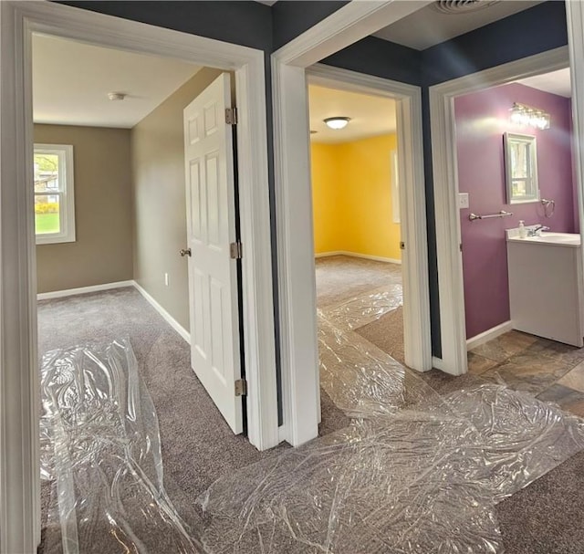 hall with baseboards and visible vents
