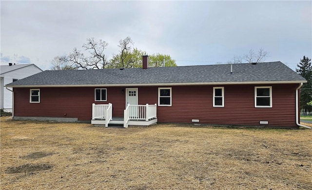 back of property featuring roof with shingles, a wooden deck, a yard, and a chimney