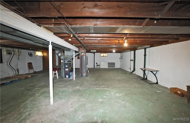 unfinished below grade area with heating unit and gas water heater