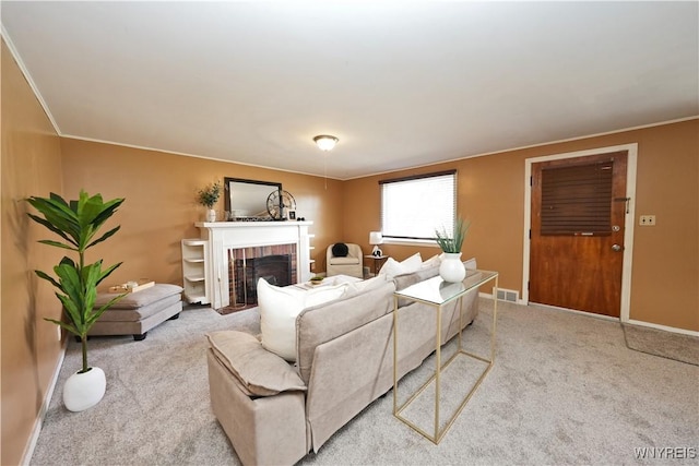 living area featuring baseboards, carpet, a brick fireplace, and visible vents