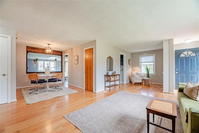 living area featuring light wood-style floors and baseboards
