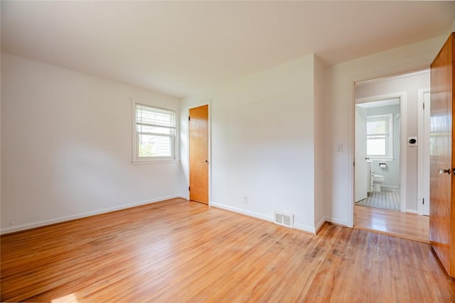 unfurnished room with visible vents, baseboards, and light wood-type flooring
