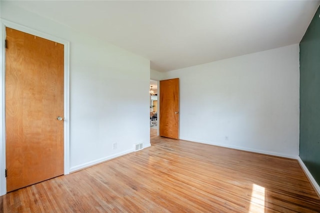 unfurnished bedroom with visible vents, baseboards, and wood finished floors