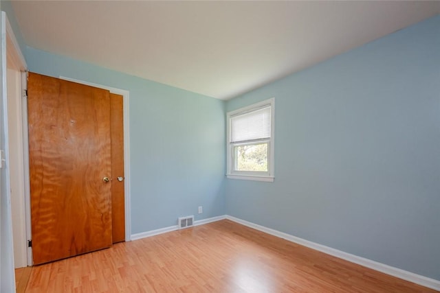 spare room with visible vents, light wood finished floors, and baseboards