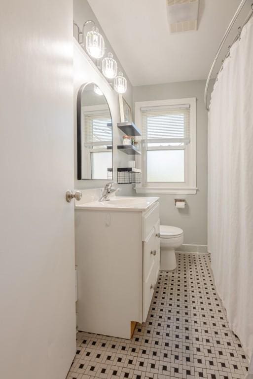 bathroom with vanity, toilet, baseboards, a shower with curtain, and visible vents