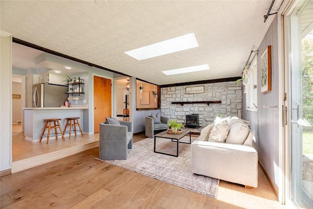 living area featuring ornamental molding, a textured ceiling, and wood finished floors