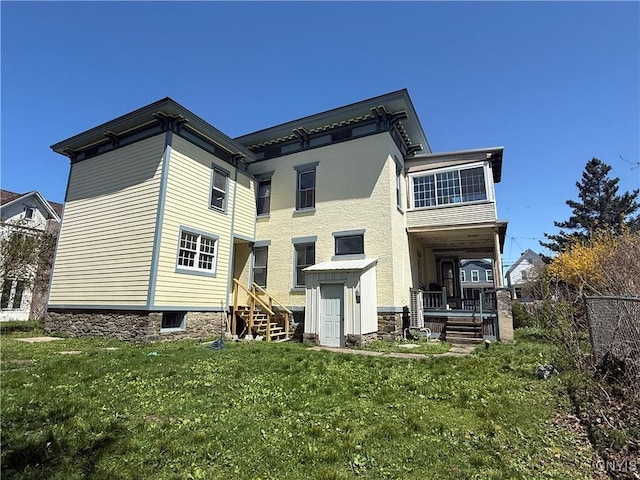 back of property featuring a yard and stairs