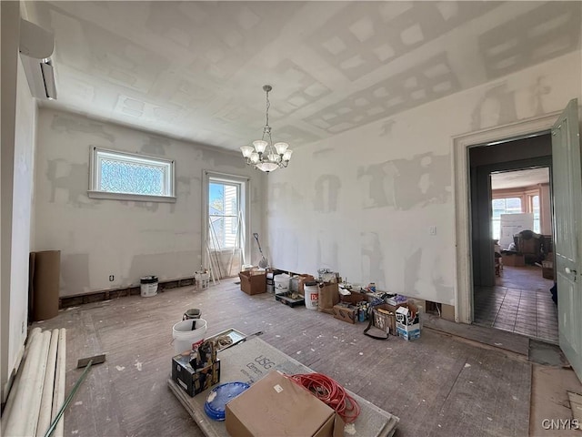 unfurnished dining area with a notable chandelier, a wall unit AC, and a wealth of natural light