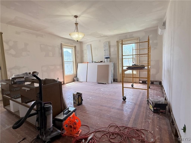 interior space with baseboards, a wall mounted air conditioner, and wood finished floors