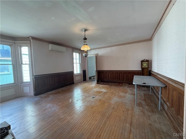 118 E 3rd St, Oswego, NY 13126 - spare room with a wall mounted air conditioner, hardwood / wood-style flooring, wainscoting, and ornamental molding