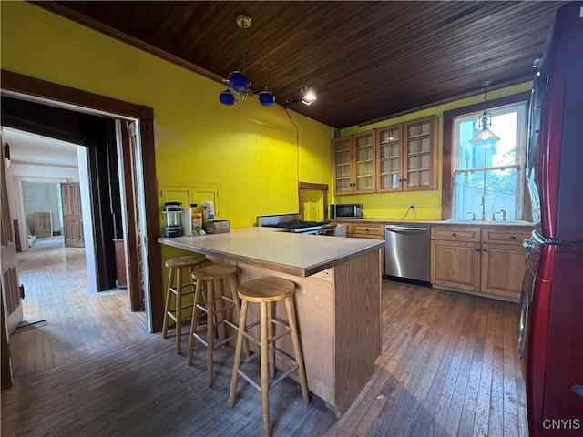 118 E 3rd St, Oswego, NY 13126 - kitchen with stainless steel appliances, a breakfast bar area, dark wood-type flooring, a peninsula, and wooden ceiling