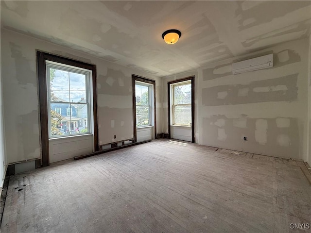 118 E 3rd St, Oswego, NY 13126 - empty room with an AC wall unit and wood finished floors