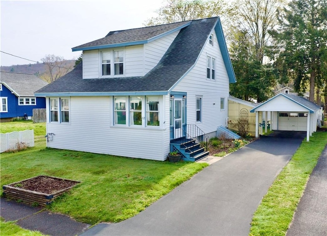 view of front facade featuring a garage, a front lawn, fence, and an outbuilding