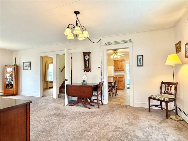 dining room with stairway, baseboards, ceiling fan with notable chandelier, and light colored carpet