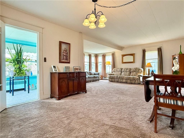 carpeted living area with a chandelier