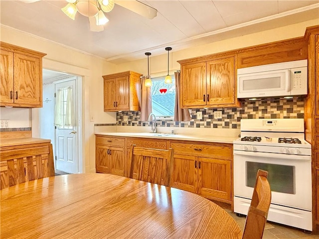 kitchen featuring ceiling fan, a sink, white appliances, light countertops, and backsplash