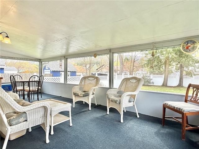 sunroom / solarium featuring carpet flooring and lofted ceiling