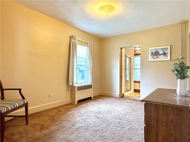 unfurnished room featuring carpet floors, baseboards, plenty of natural light, and radiator