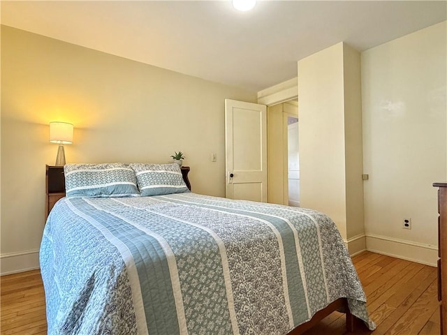 bedroom featuring baseboards and hardwood / wood-style flooring