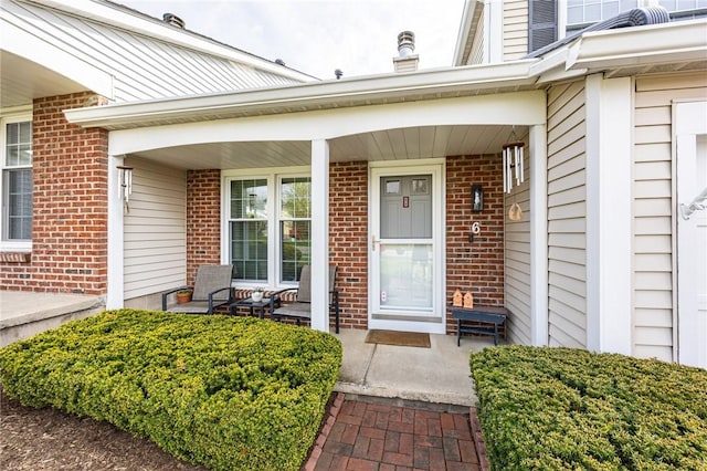 property entrance with brick siding and covered porch