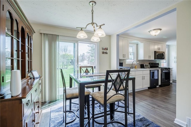 dining area featuring dark wood-type flooring and a textured ceiling