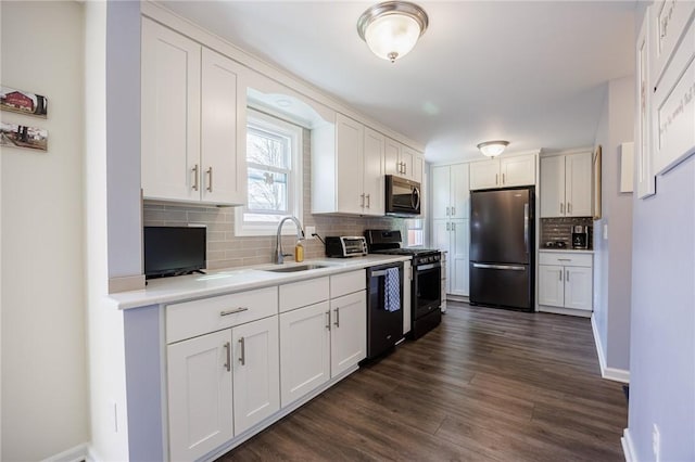 kitchen featuring range with gas stovetop, freestanding refrigerator, dishwashing machine, white cabinetry, and a sink