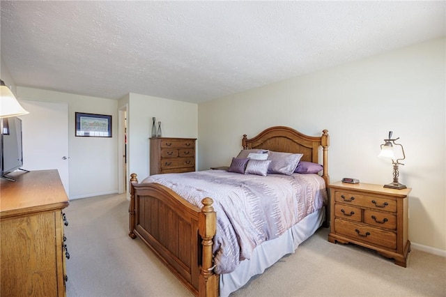 bedroom with a textured ceiling, light colored carpet, and baseboards
