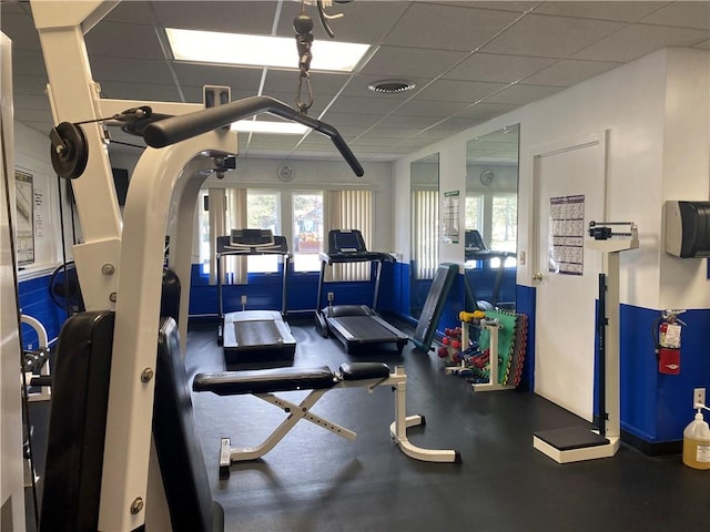 workout area with a drop ceiling and visible vents