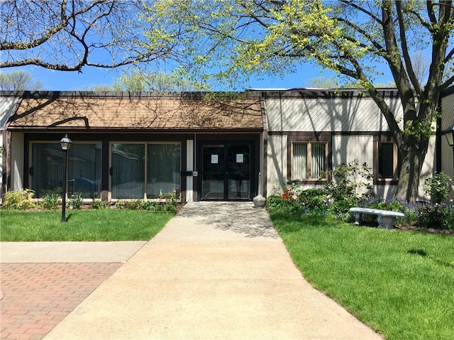 view of front of home with a front lawn and french doors