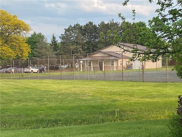 view of community featuring fence and a yard