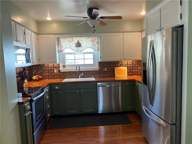 kitchen featuring plenty of natural light, a sink, white cabinetry, and stainless steel appliances