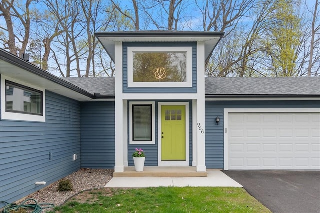 view of front of house with driveway, a shingled roof, and a garage