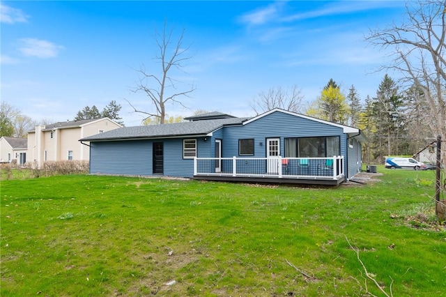 rear view of property with a yard and a wooden deck