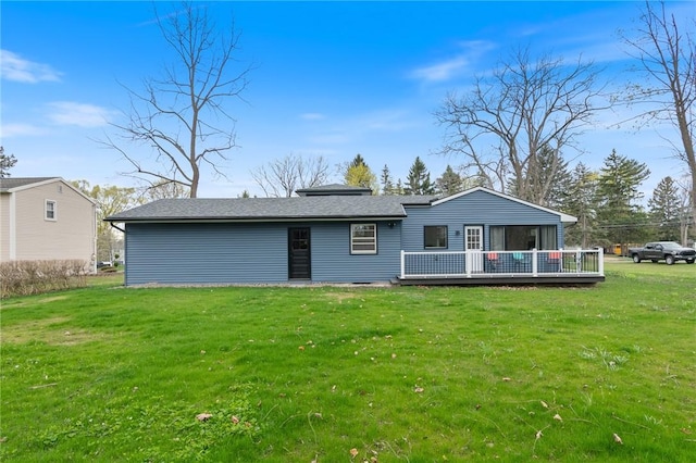 rear view of house with a wooden deck and a yard