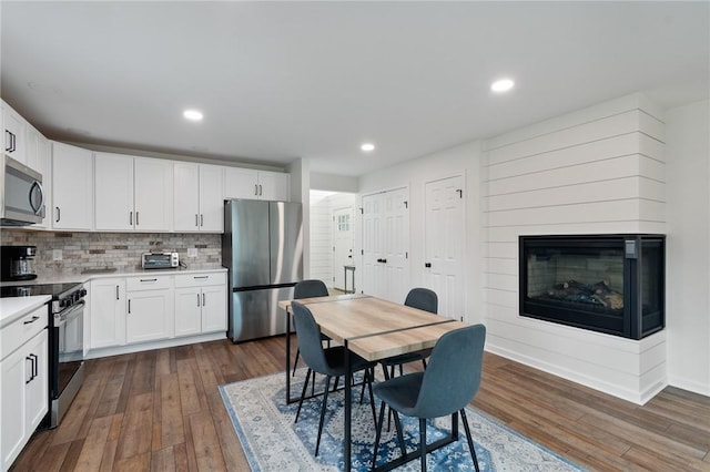 kitchen featuring white cabinets, stainless steel appliances, and dark wood-style floors