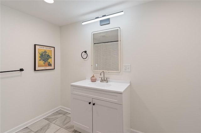 bathroom with baseboards, marble finish floor, and vanity