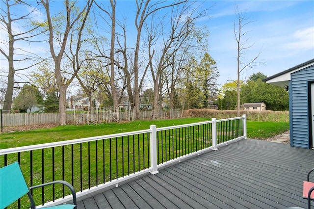 wooden terrace featuring a lawn and fence