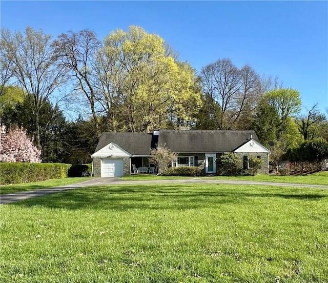 single story home featuring a garage, aphalt driveway, and a front yard